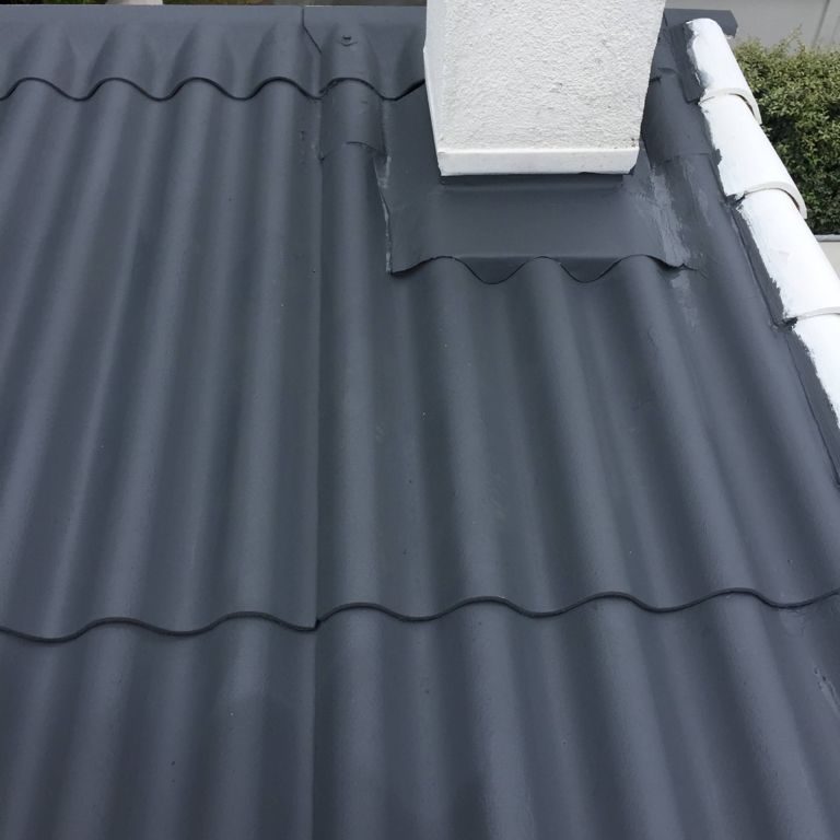 Toiture en plaques peinte en anthracite autour d'une cheminée