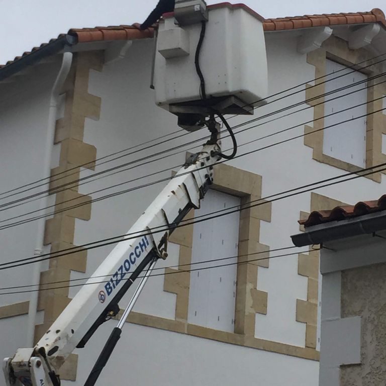Façade en pierre et enduit d'une maison charentaise, nacelle en place