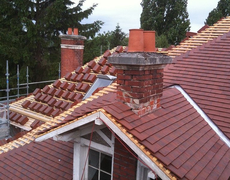 Chantier de toiture en cours, couverture partiellement déposée